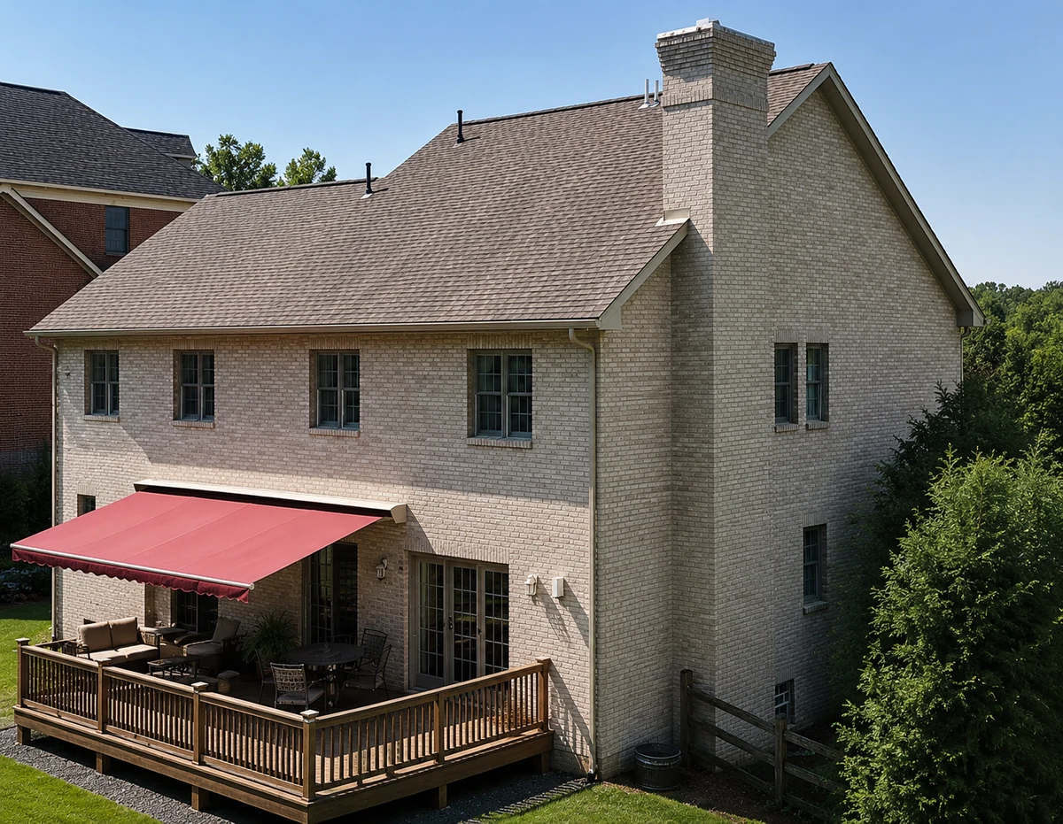 The same house 25 years later surrounded by mature trees, the stained brick still one even cream color