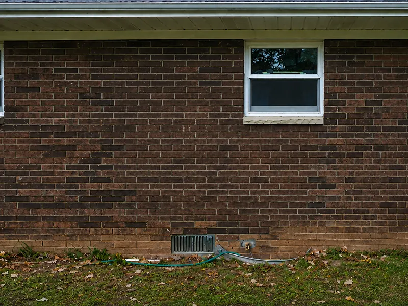 The same brick wall after staining, the replacement patch blended in to match the original masonry