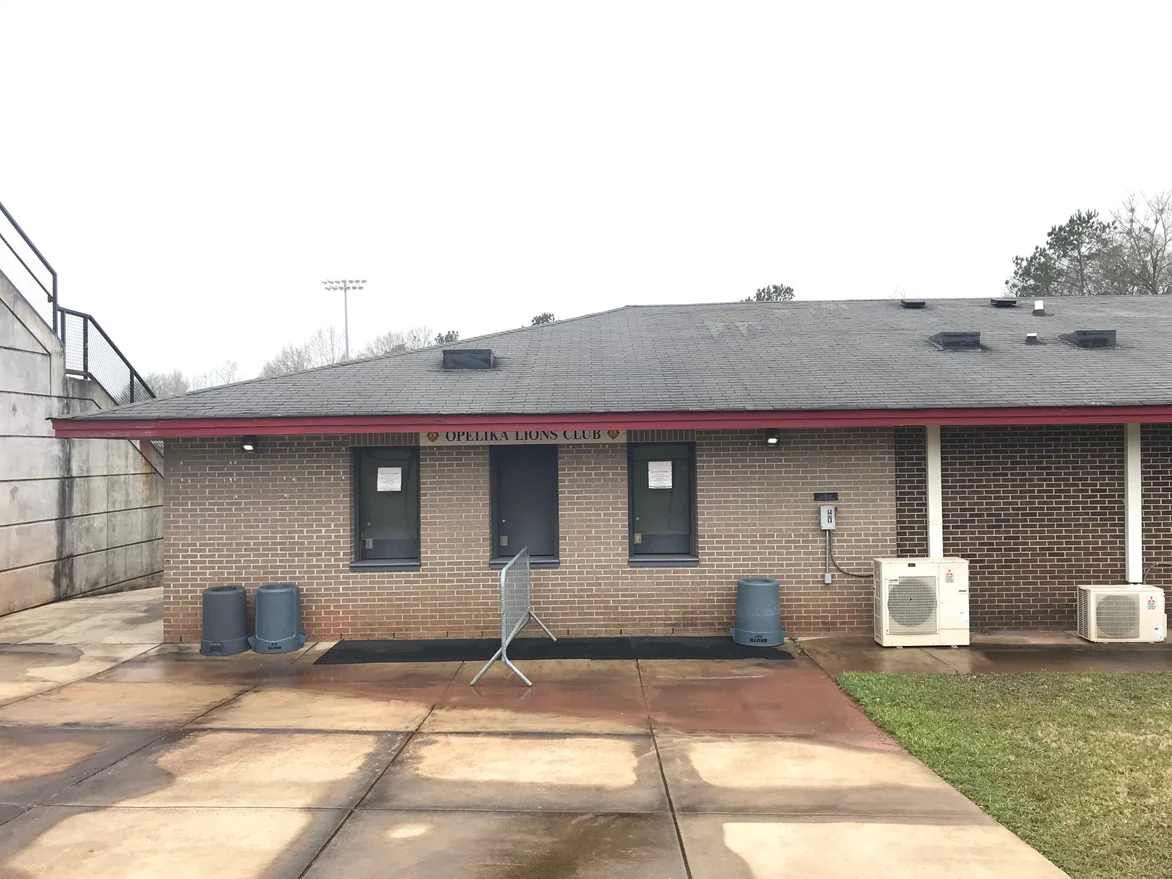 A concessions building at the stadium in 2021, tan brick with pale mortar joints around two shuttered service windows and a door