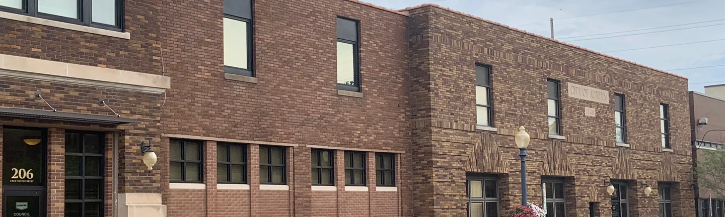 Auburn City Hall along the street in 2019, its brick reading as one range from the entrance block to the far wing
