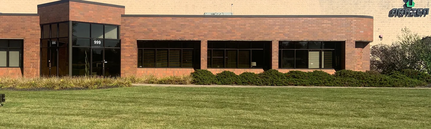 The front of the Aurora office building in 2019, its brick one even darker red across the entry and the window bays