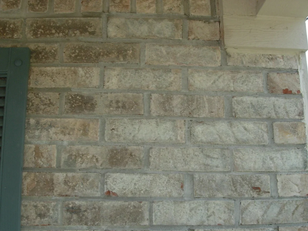 The same corner in 2007 after staining, the mottled units brought into the buff, tan and grey range of the wall around them