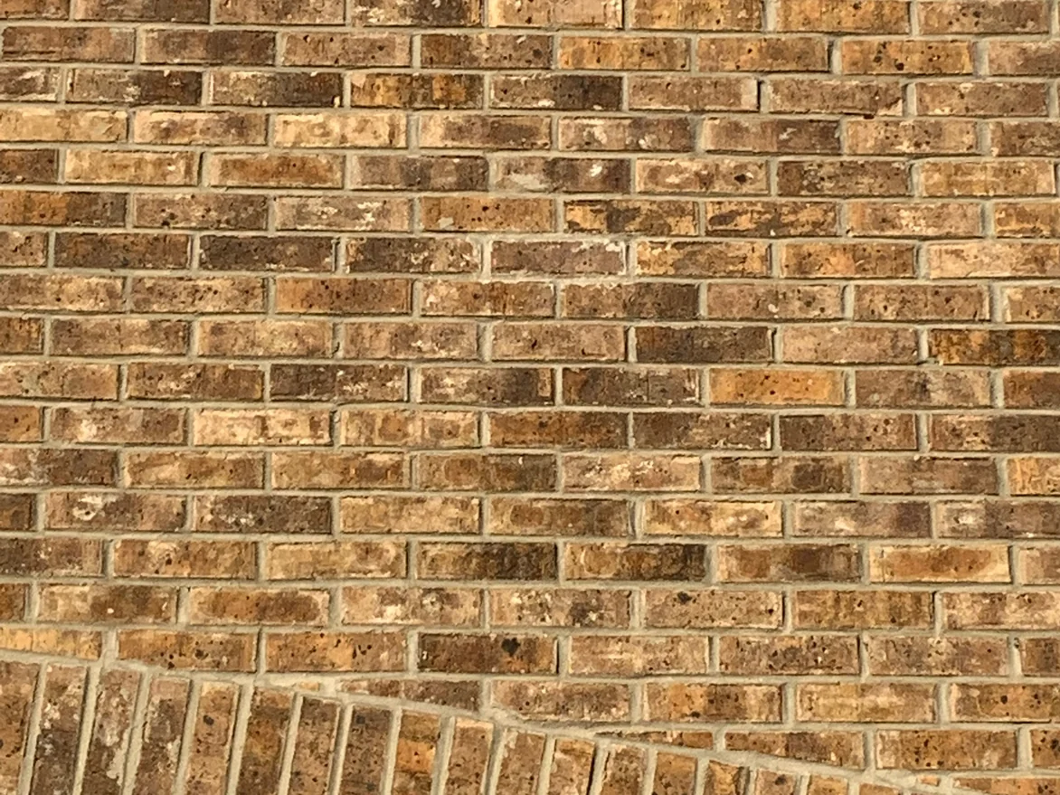 The gable brick at unit scale in 2019, tan, gold and brown units with pale mortar joints running down to the soldier course arch