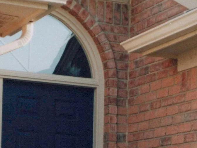 The brick arch over the front door in 1998, cream trim on the arch and a dark door below, the units around it reading in several shades