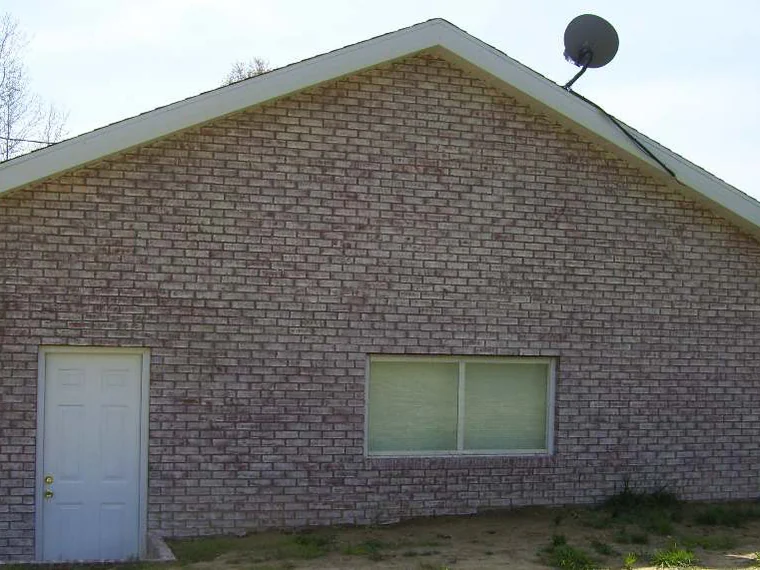 The same gable end later in 2008, the brick carried to one soft pink range across the wall and the gable, ground still bare