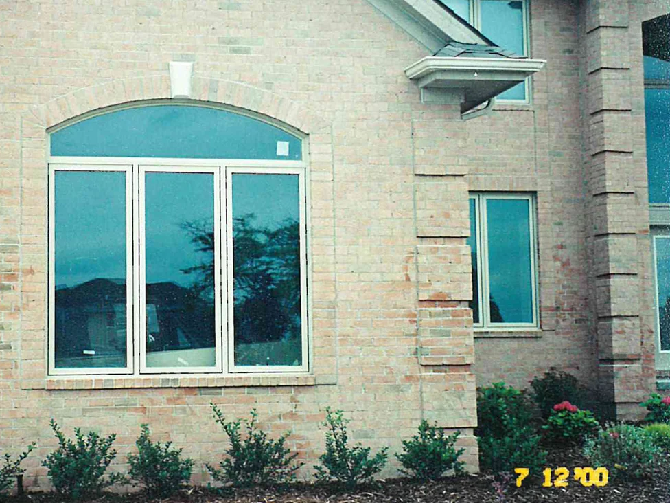 The front of the house in 2000, the brick around its arched window running pale cream and grey with patches of bare salmon
