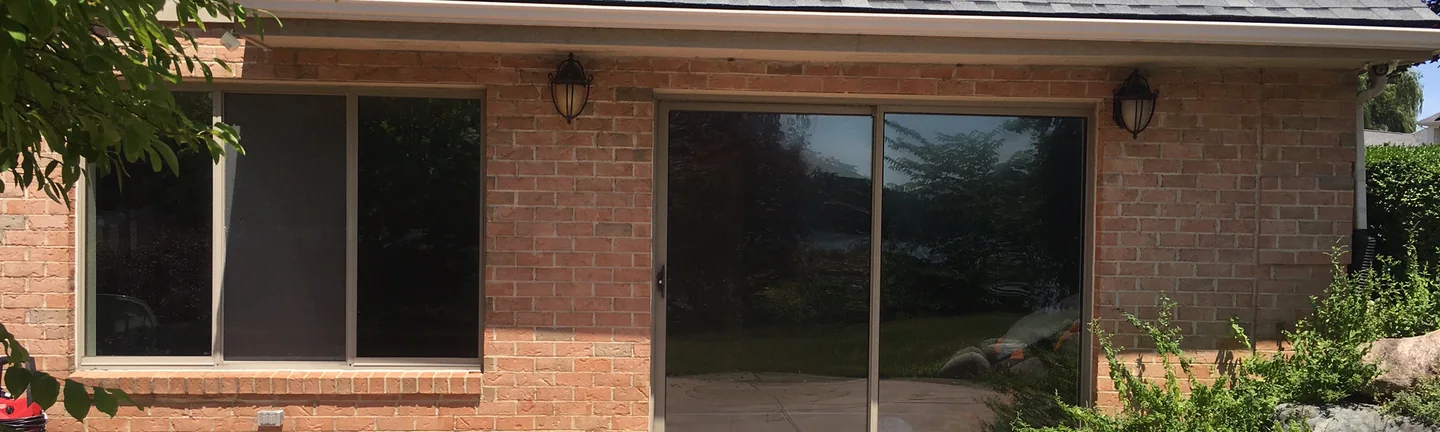 The rear wing of a Belleville house in 2019, its brick one even range of red and tan between two lanterns
