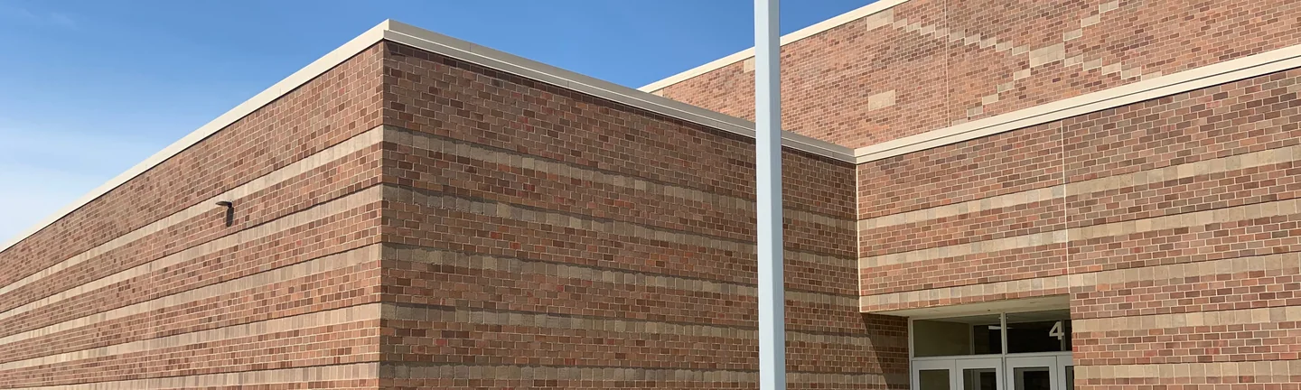 The corner of Bluffton High School in 2019, its brick reading as one red and brown range along both walls