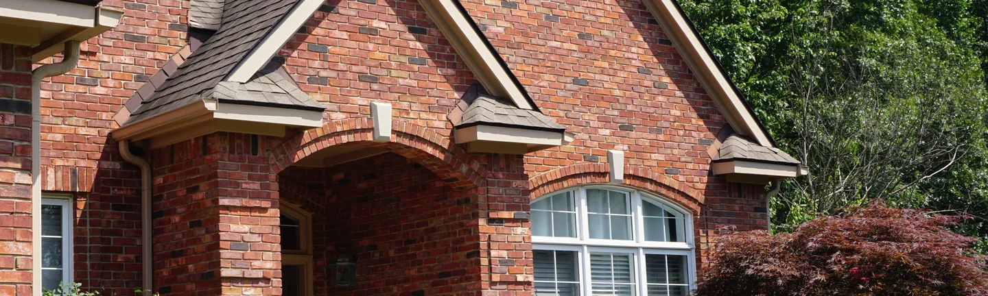 The brick entry gable of a Brighton, Michigan house in 2019, its whites sitting inside one red and brown range