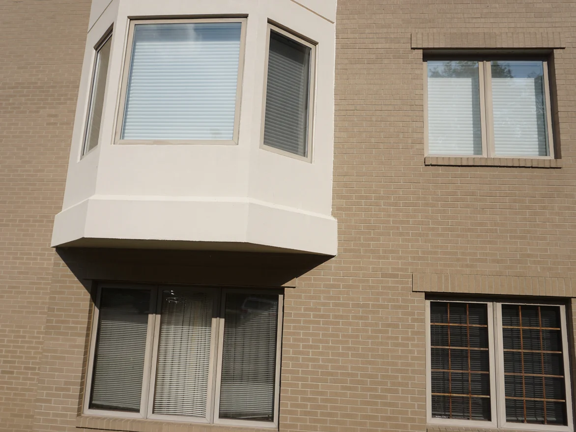 Close view of the brick around a bay window in 2019, the units holding one cream range across every course