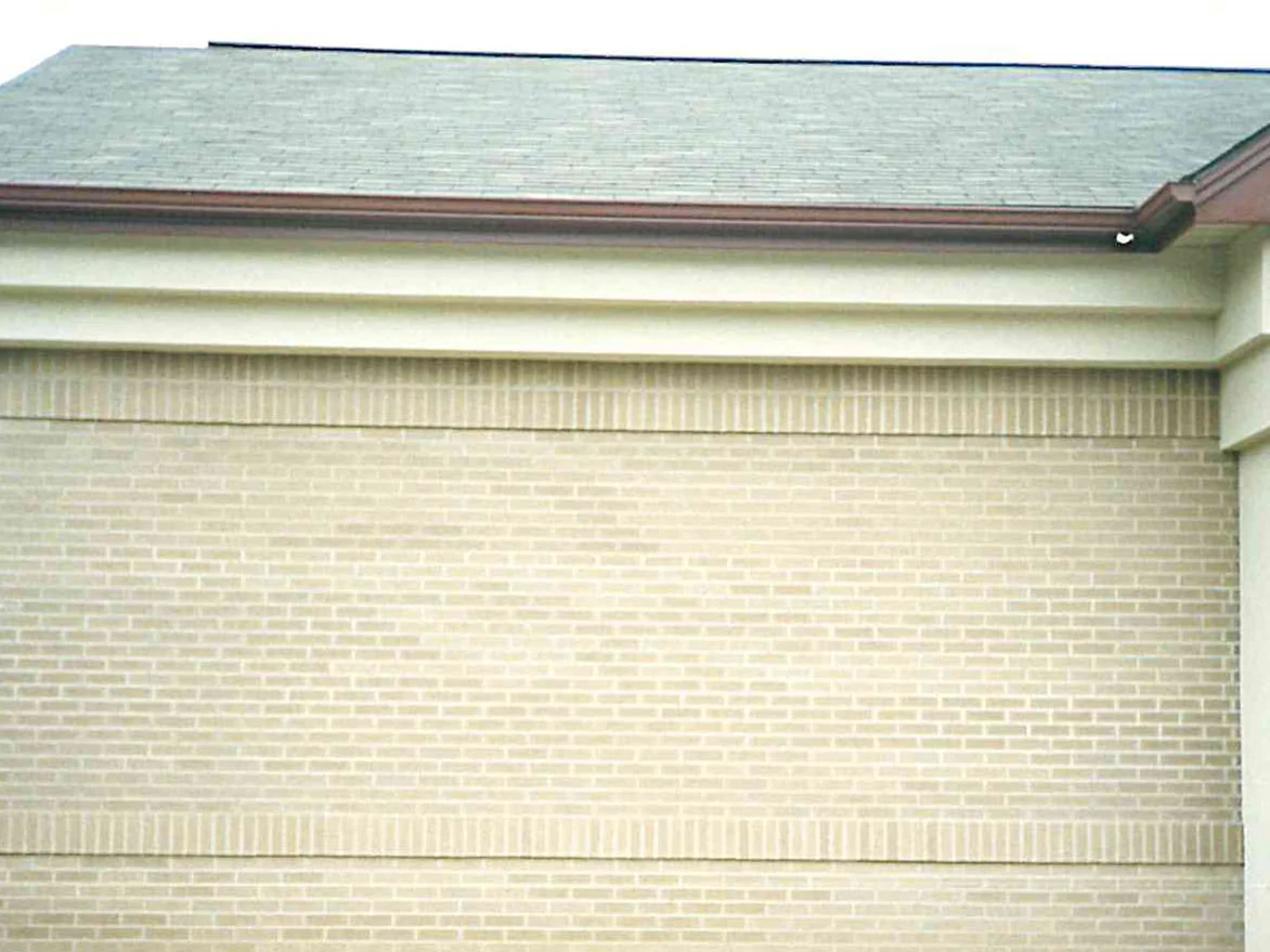 A single-storey wall on the community during the 1994 work, cream brick with soldier courses banding it above and below