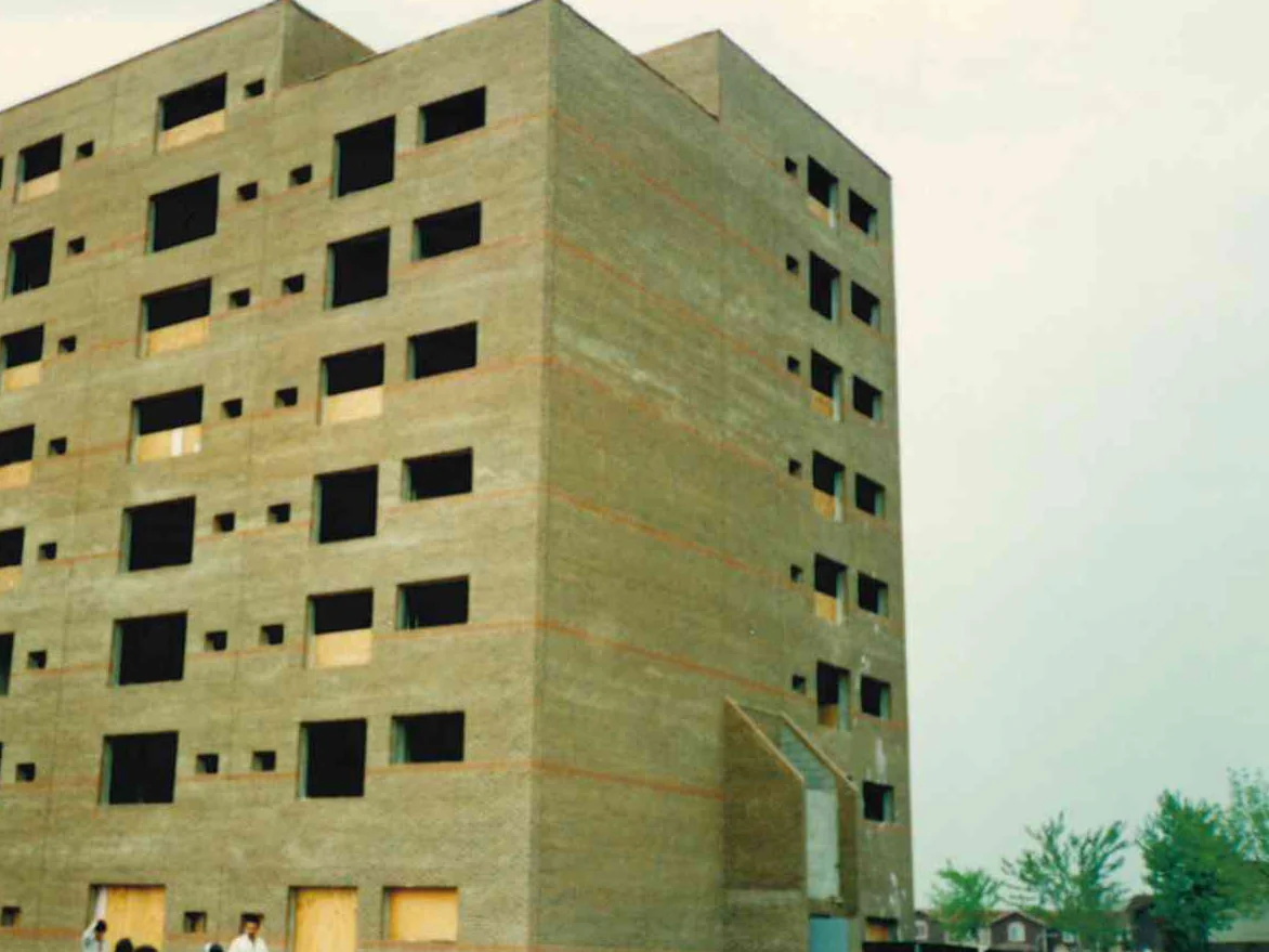 The high rise under construction in 1994, its brick a pale buff with orange banding and the window openings still boarded