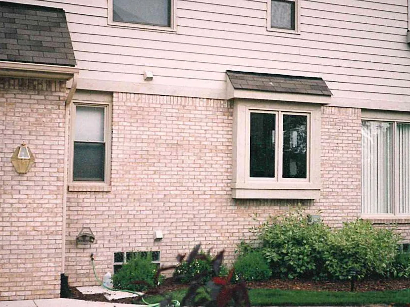 The same side wall later in 1997, the brick reading as one even cream and tan blend from the garage corner past the bay window
