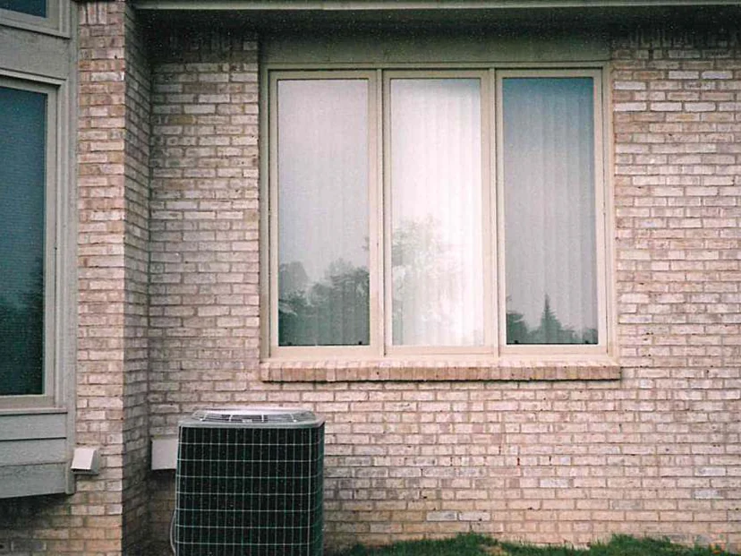 The same window and air conditioning unit later in 1997, the brick around them an even blend with no pale patch