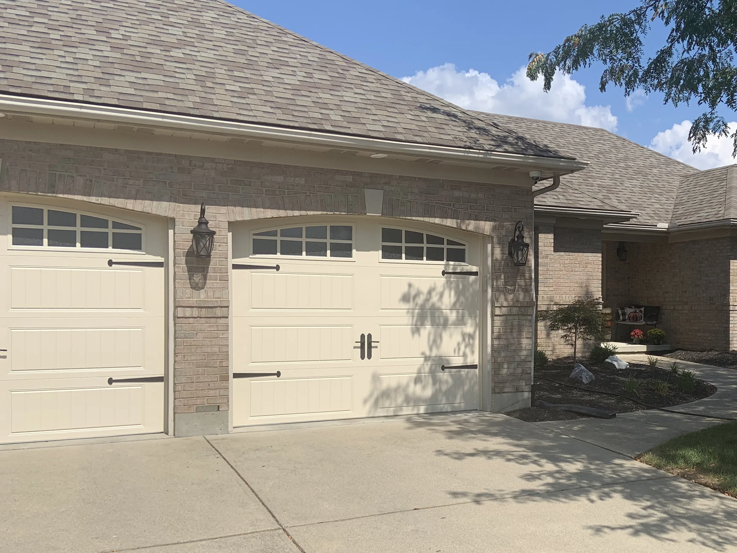 The garage bays at close range in 2019, the brick an even mix of cream, tan and pale pink under a darker soldier course
