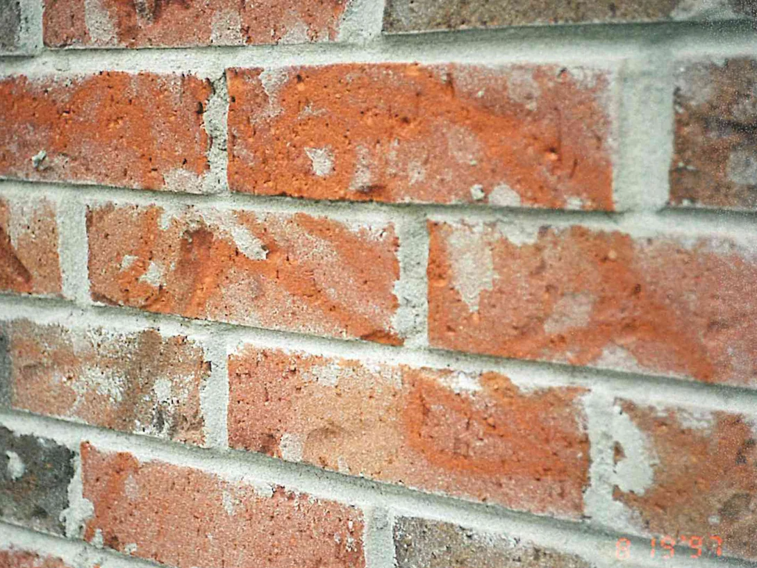 Close view of the brick in 1997, pale scoured patches across the faces where a pressure washer wand cut into them
