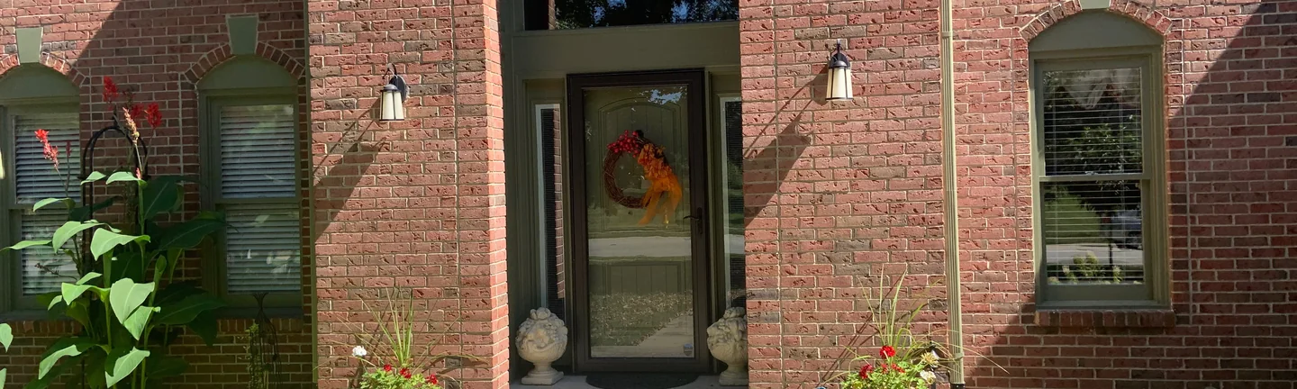 The front entry of the Carmel house in 2019, the brick either side of the door reading as one even red and brown range