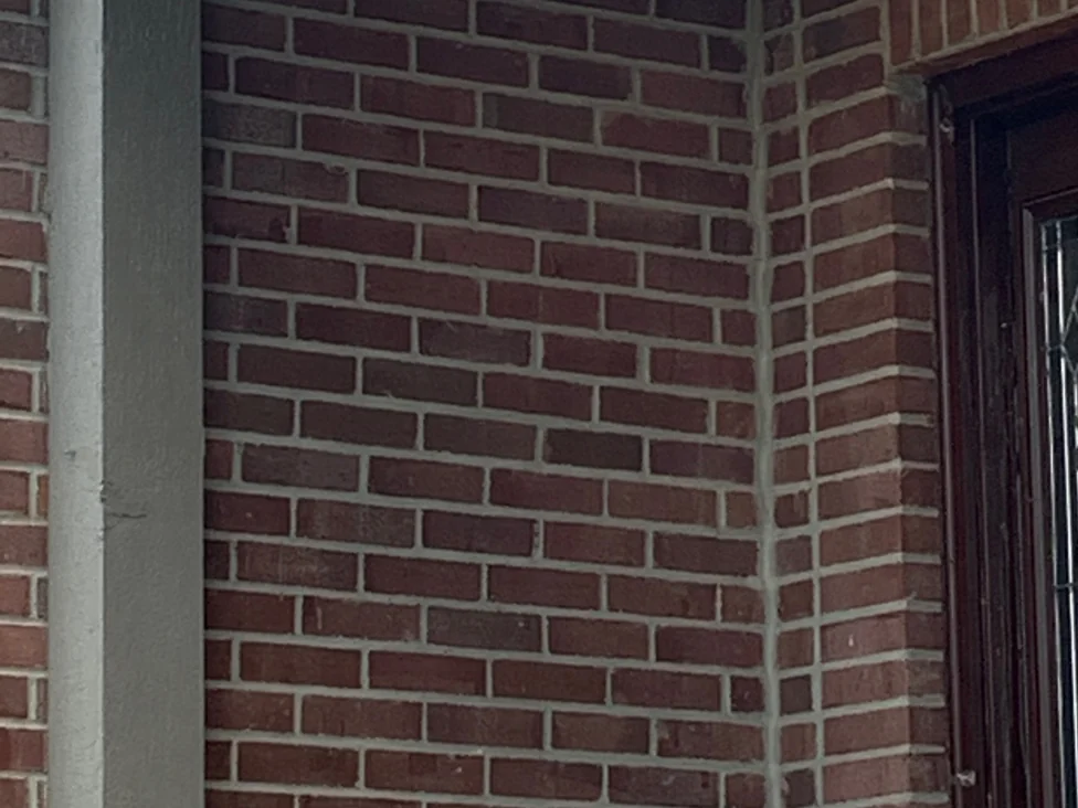 The brick returns inside the entry porch in 2019, the outside corner and both faces carrying the same even blend in shade