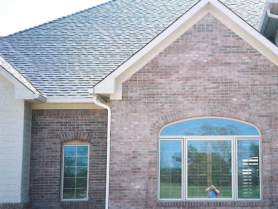 The gable end of a Carmel, Indiana home in 2003, light and dark brick units mixed around an arched window