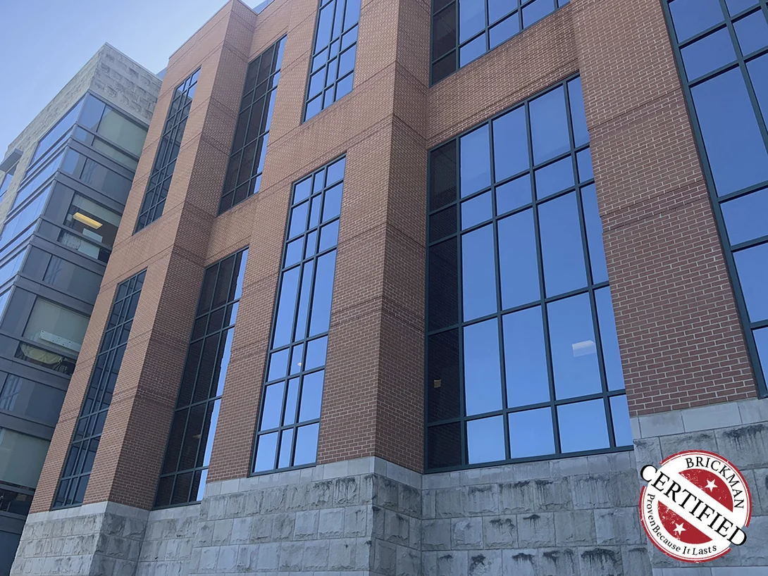 Looking up the brick and glass bays in 2019, the brick an even red range from the limestone base to the top floor