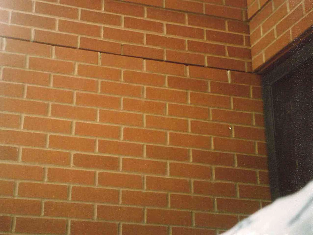 Close view of an outside brick corner in 2004, the units reading as one red range across both faces with pale mortar joints