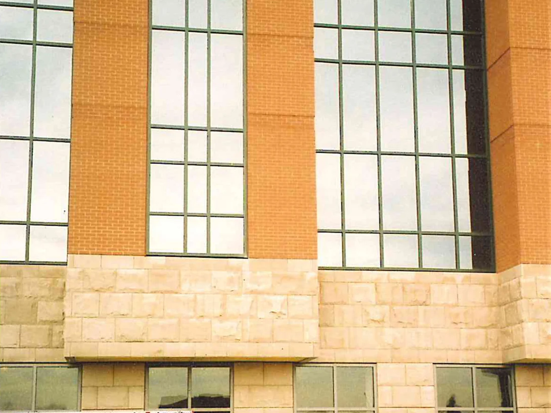 The medical center still under construction in 2004, tall window bays set in orange brick above a limestone base, with a Masonry Cosmetics pickup parked at the wall