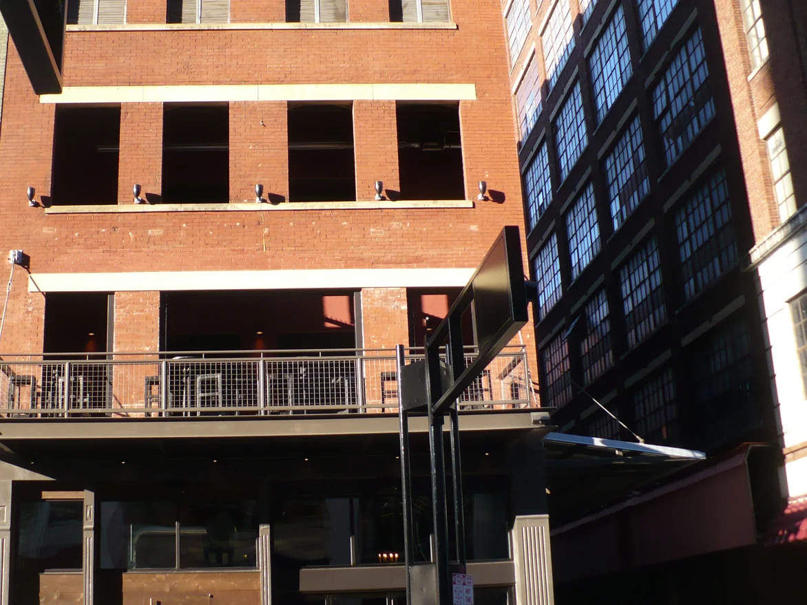 The same elevation after staining in 2012 in low direct sun, brick and mortar reading as one red brown range