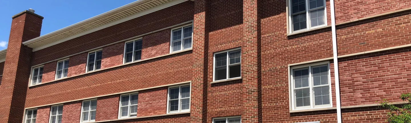 Clark Center in 2019, the brick reading red across the window bands that were once white