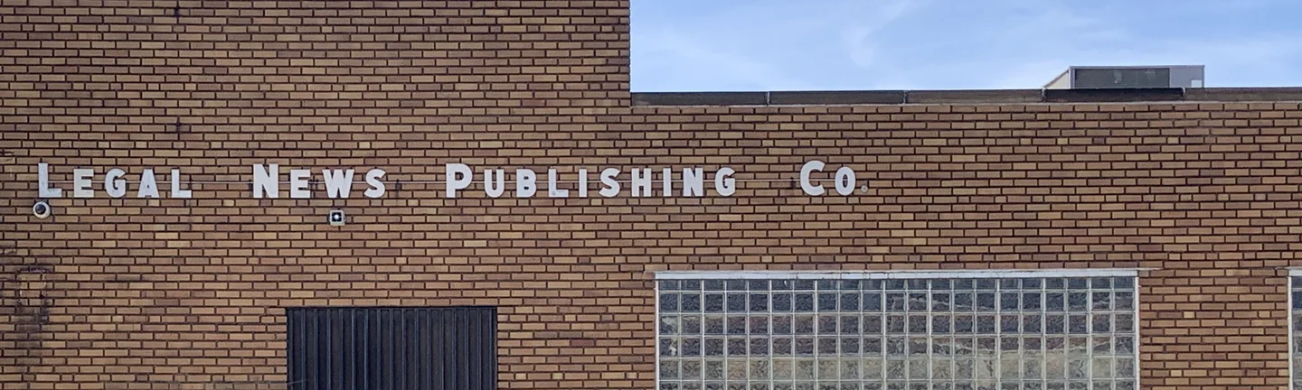 The brick elevation of a single-story Cleveland office in 2019, one red brown range across the wall
