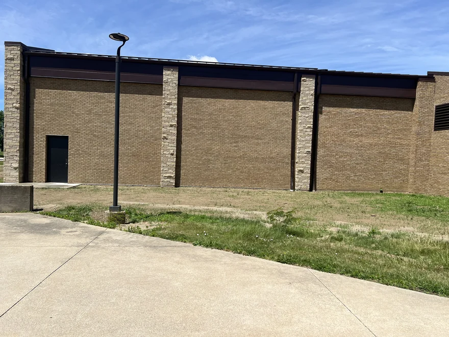 The same commercial wall after staining, the new brick now the same tan as the older brick beside it