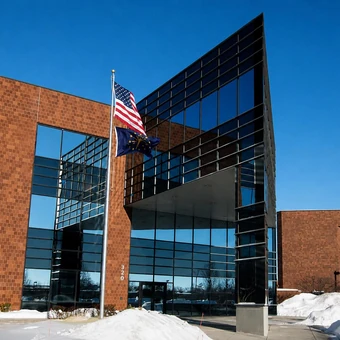 Brick and glass office building with flags on poles out front