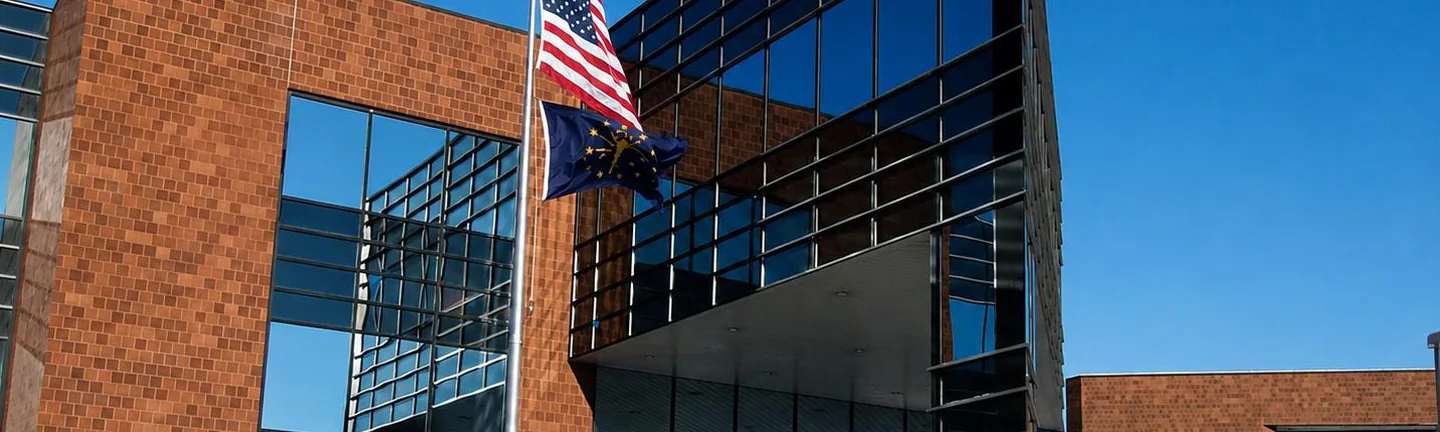 Brick and glass office building with flags on poles out front