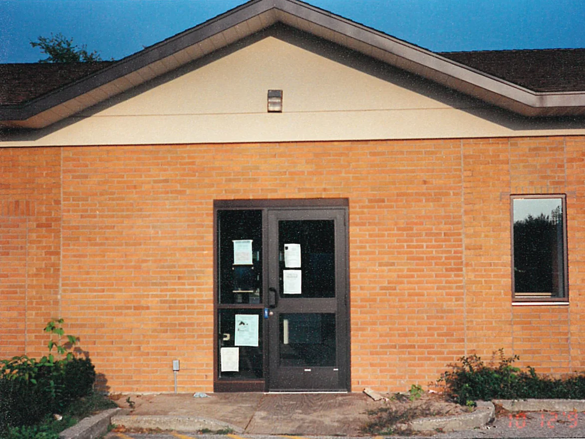 The library entrance doors set under a gable in October 1997, the brick running across the wall on both sides of them as one even orange