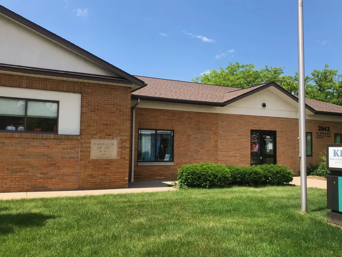 The library frontage in 2019 looking past the cornerstone along the wall to the glass entrance door and the branch name sign