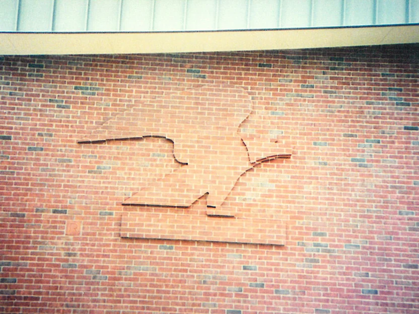 Close view of the brick eagle sculpture in 1994, its raised units noticeably lighter than the wall around them