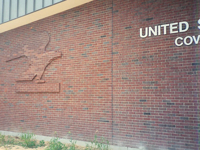 The eagle wall in 1994, the sculpture's brick reading paler than the field around it, with the building's cast lettering on the return wall