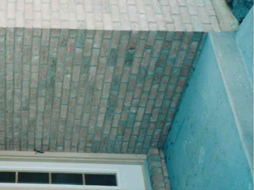 The same recessed entry corner in 1998 after the work, the wall beside the door reading as one buff range with no dark band