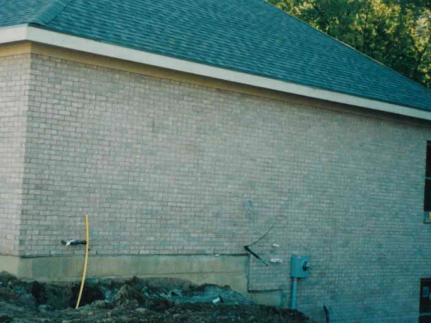 The side wall of the house in October 1998 after the work, the buff brick one even range from the foundation to the eaves, the hose and meter box still at the base