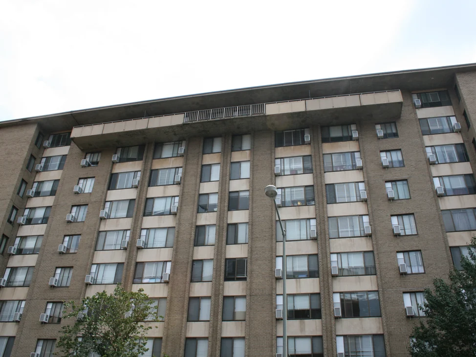The apartment block from the ground in 2019, its brick one even buff range under a deep concrete cornice