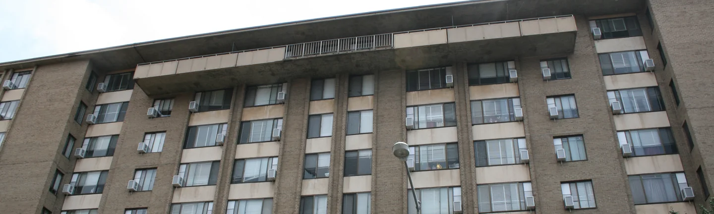 The apartment block in 2019 seen from below, its brick one even buff under a deep concrete cornice