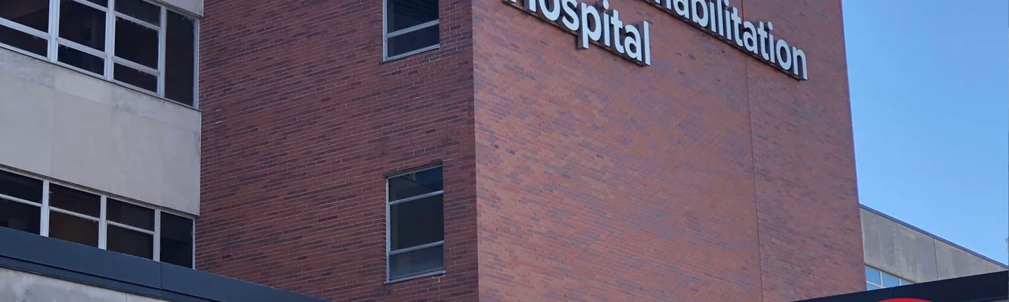The brick corner above the hospital entrance in 2021, red brick running past three windows under the Dodd Rehabilitation Hospital letters