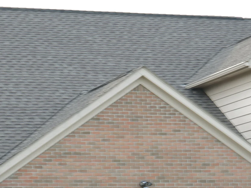 The house from the driveway in 2019, the brick gable holding one even range where it meets the cream siding of the wing beside it