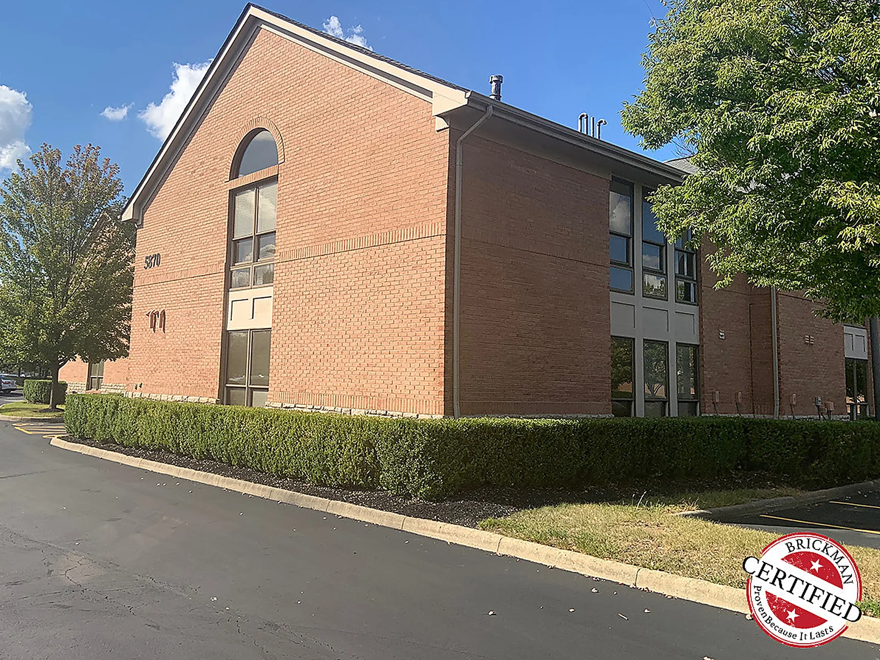The office seen from the parking lot drive in 2019, the gable end and the long elevation beyond it reading as one red brick range