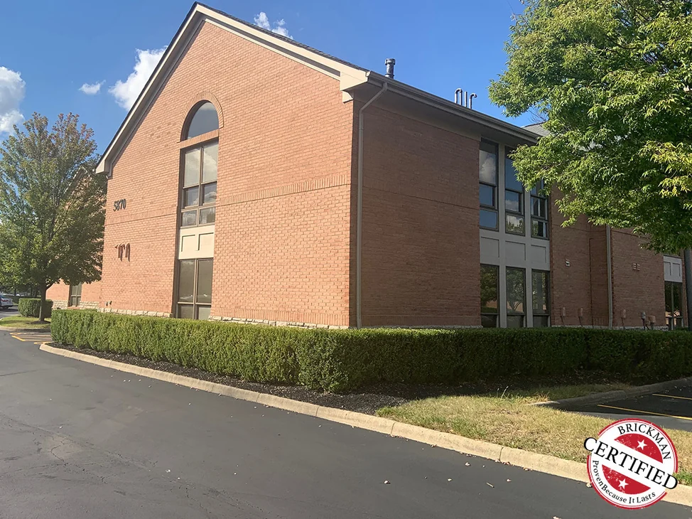 The office seen from the parking lot drive in 2019, the gable end and the long elevation beyond it reading as one red brick range.