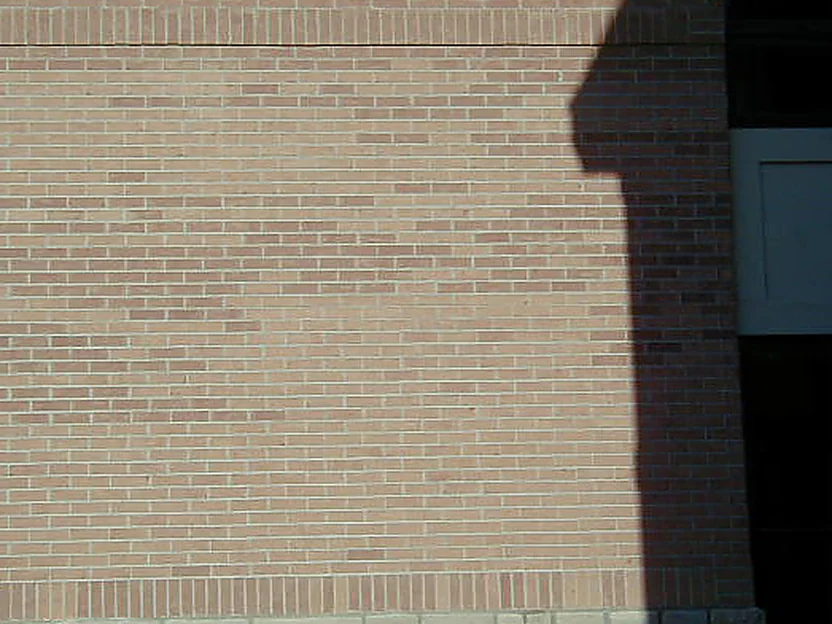 A wall of the office part way through the work in 2005, the brick above the stone base reading paler across the middle of the elevation