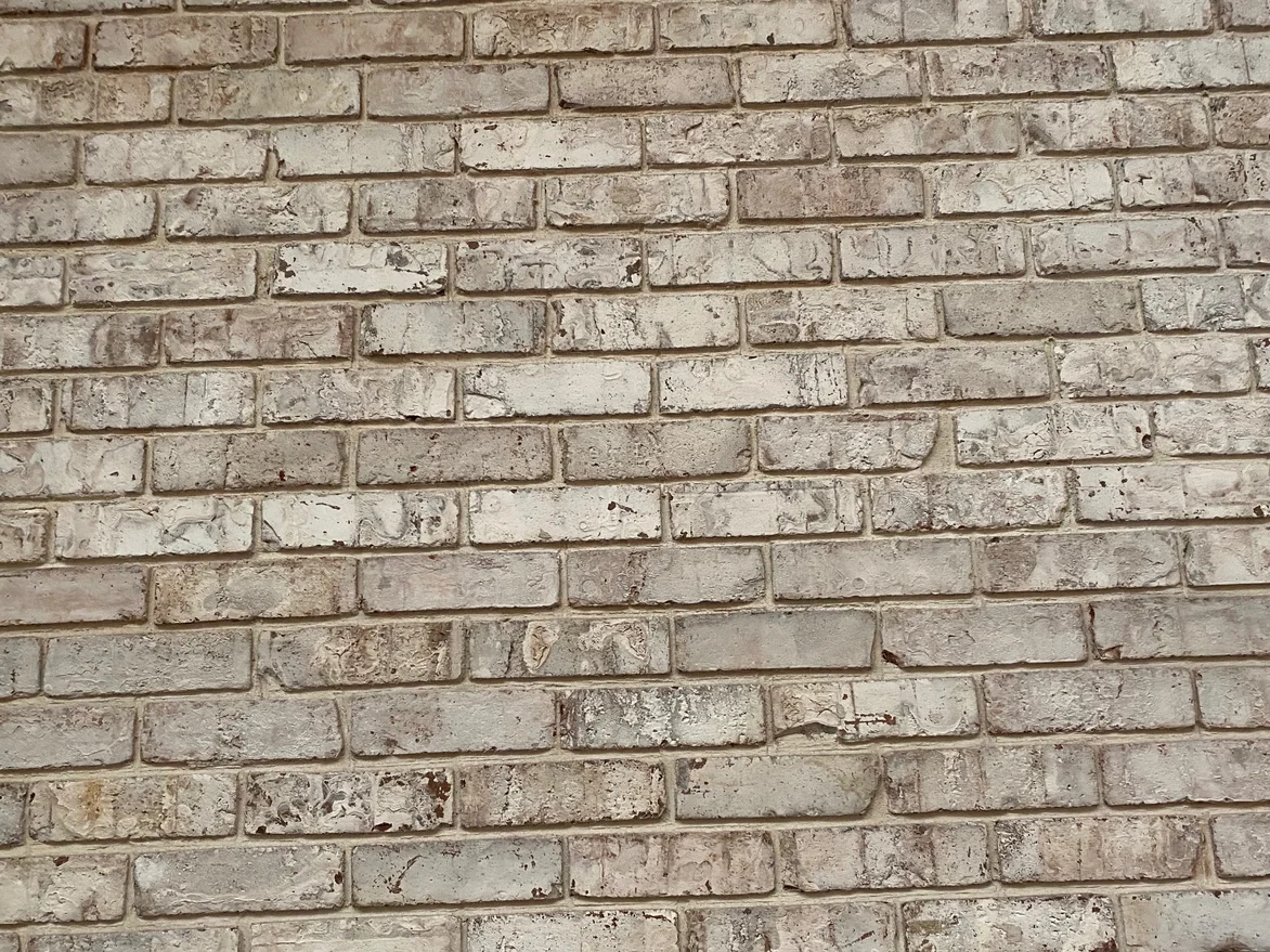 The stained wall in 2021 at unit scale, every brick sitting inside one narrow cream range across the courses with no dark unit standing out of it