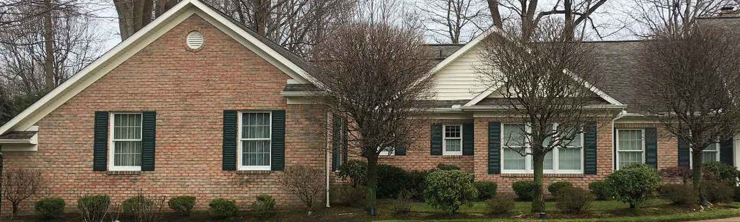 A wide band of the house in 2021, one even red range of brick running past shuttered windows to the far wing