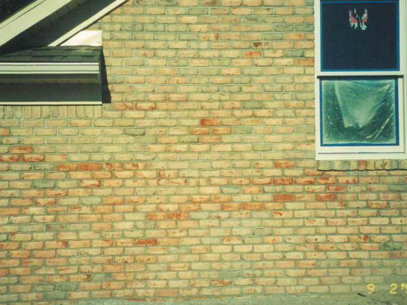 A close view of the wall in 1999, cream brick broken up by scattered orange and red units, with the camera date 9 2 99 burned into the corner
