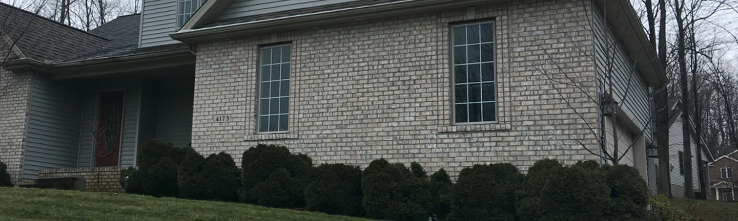 Buff brick across the front of the Erie home in 2020, one range from the entry to the garage wing