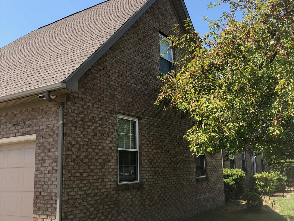 The garage end of the house in 2019, the brick running as one variegated tan and brown from beside the garage door up to the gable window